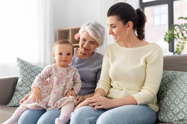 Anya, lánya és nagymamája otthon a kanapén Stock Kép