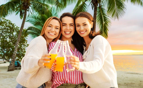 Mulheres jovens brindando bebidas não alcoólicas na praia — Fotografia de Stock