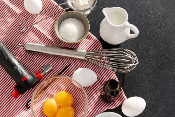 Whisk, ovos, açúcar, leite, farinha e baunilha — Fotografia de Stock