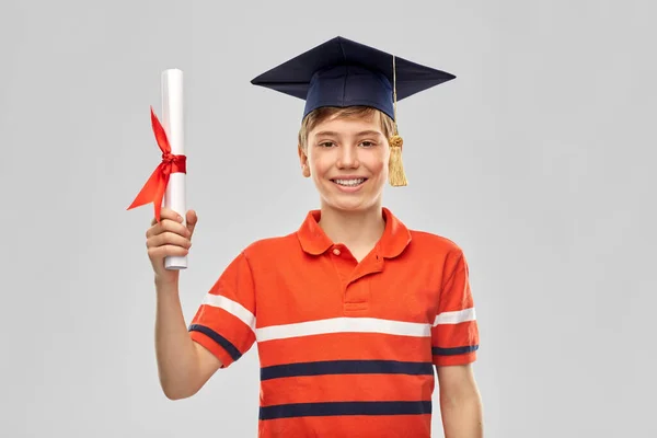 Étudiant diplômé garçon dans mortarboard avec diplôme — Photo