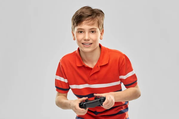 Усміхнений хлопчик з геймпадком грає у відеогру — стокове фото