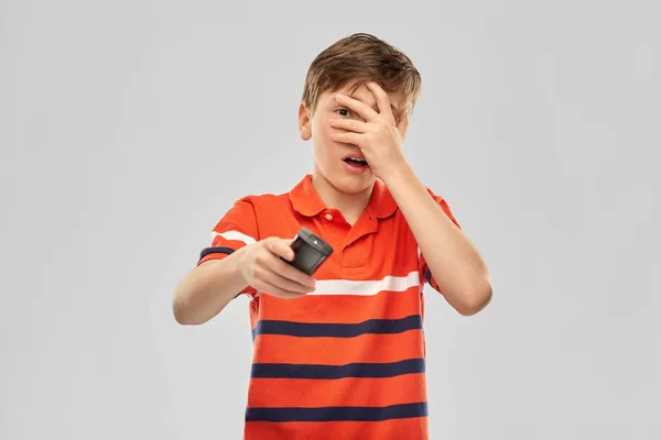 Scared boy with tv remote control — Stock Photo, Image