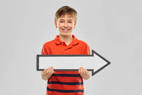 Happy boy holding big white rightwards thick arrow — Stock Photo, Image
