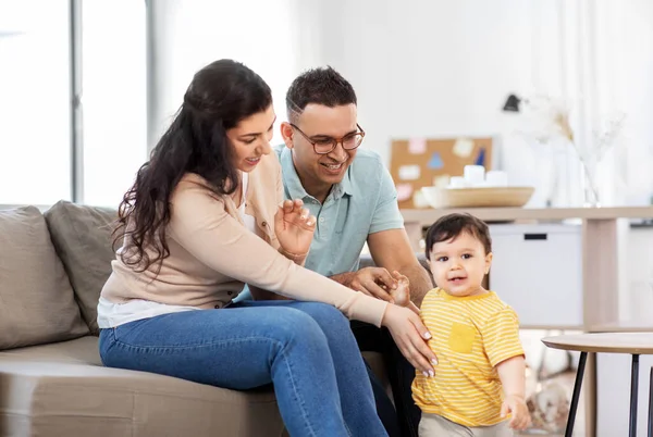 Šťastná rodina s dítětem sedí na pohovce doma — Stock fotografie