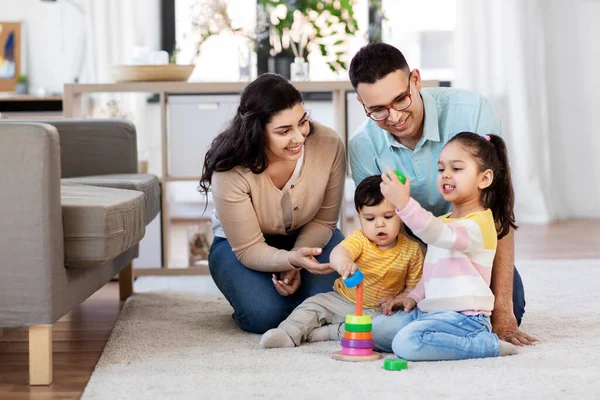 Feliz familia jugando con pirámide juguete en casa — Foto de Stock