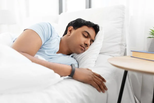 Индийский мужчина спит в постели дома — стоковое фото