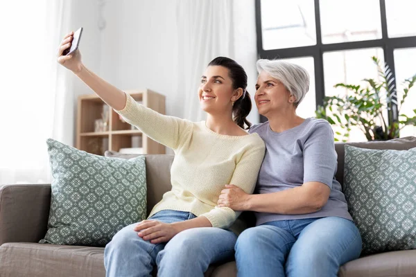 Seniorin mit Tochter macht Selfie zu Hause — Stockfoto