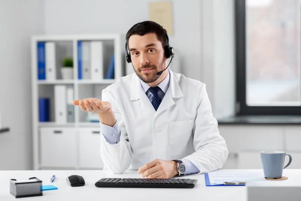 Mannelijke arts in headset met videogesprek in kliniek — Stockfoto