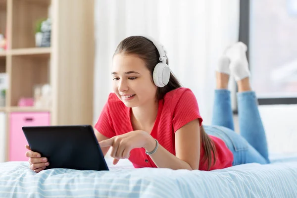 Dziewczyna w słuchawkach słuchanie muzyki na tablecie — Zdjęcie stockowe