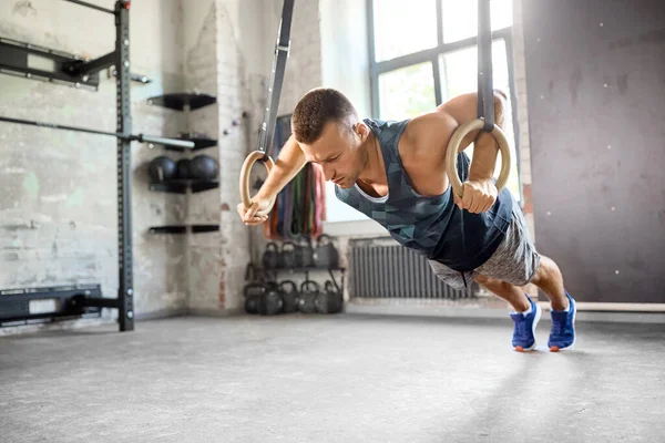 Man doet push-ups op gymnastische ringen in de sportschool — Stockfoto