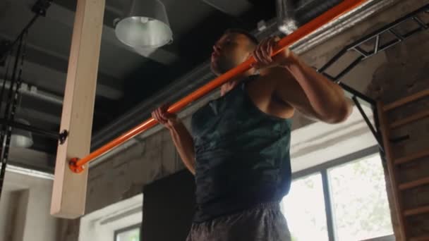 Mężczyzna ćwiczenia na barze i robi podciąganie w siłowni — Wideo stockowe