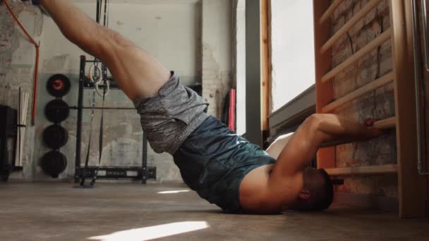 Homme faisant de l'exercice dans les bars muraux de gymnastique dans la salle de gym — Video