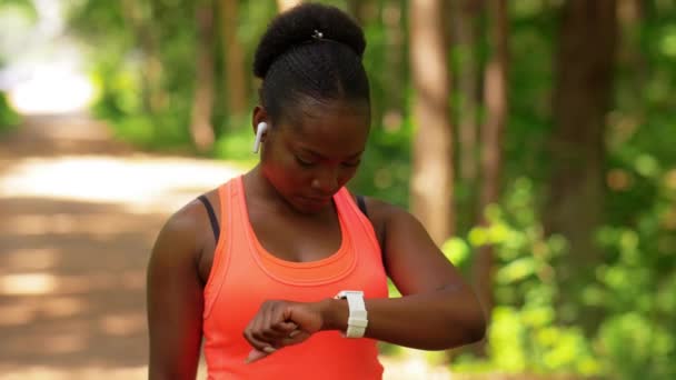 Africká žena se sluchátky a chytrými hodinkami — Stock video