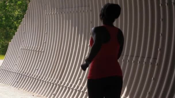 Mladá africká americká žena běží v tunelu — Stock video