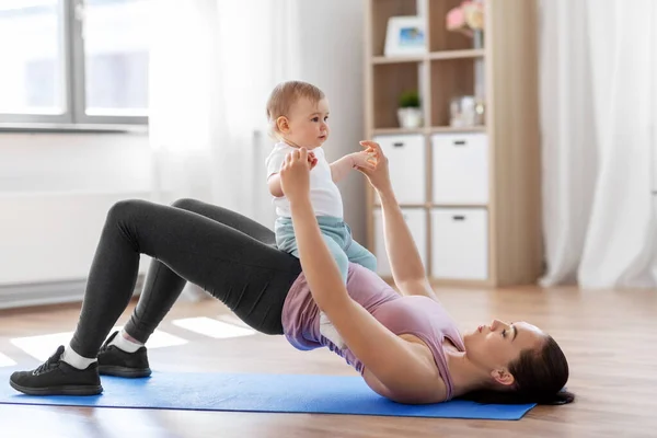Mãe com pequeno bebê se exercitando em casa — Fotografia de Stock