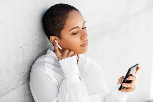 Donna afroamericana con auricolari e telefono — Foto Stock