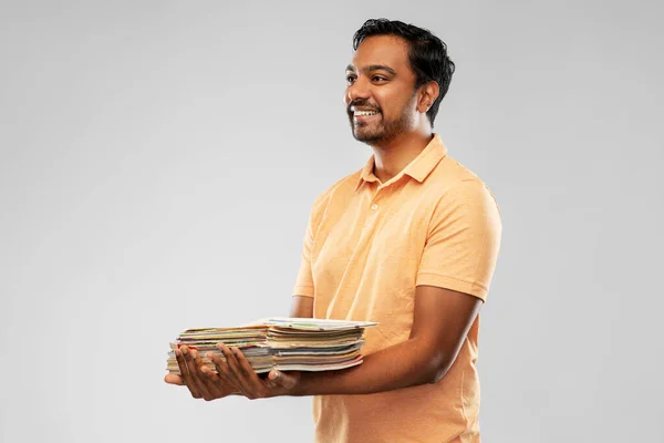 Усміхнений молодий індійський чоловік сортує паперові відходи — стокове фото