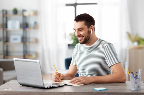 Uomo con notebook, auricolari e laptop a casa — Foto Stock