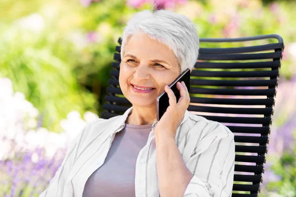 Feliz mujer mayor llamando por teléfono en el jardín —  Fotos de Stock