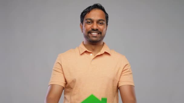 Mosolygós indiai férfi kezében zöld ház ikon — Stock videók