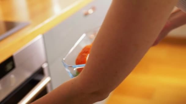 Женщина приготовление пищи в духовке на домашней кухне — стоковое видео