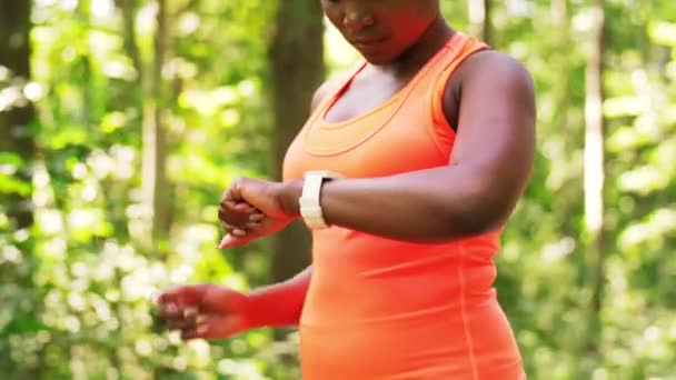 Mujer africana con auriculares y reloj inteligente — Vídeo de stock