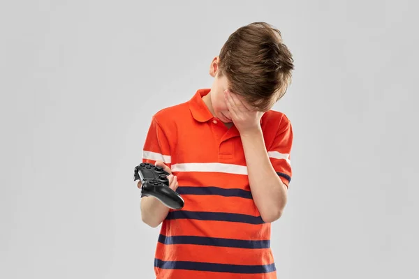 Malheureux garçon avec gamepad jouer jeu vidéo — Photo