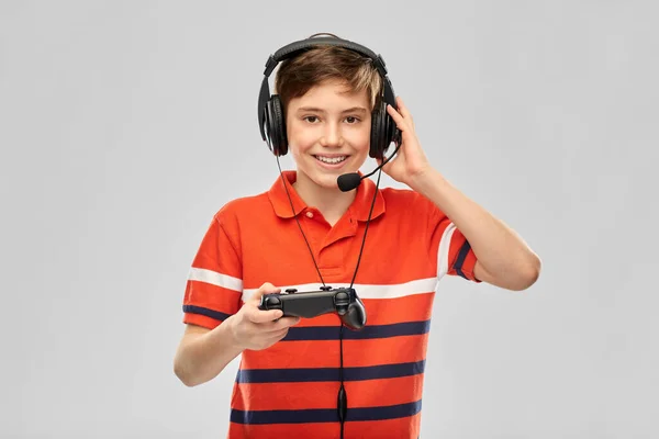 Jongen in hoofdtelefoon met gamepad spelen video game — Stockfoto