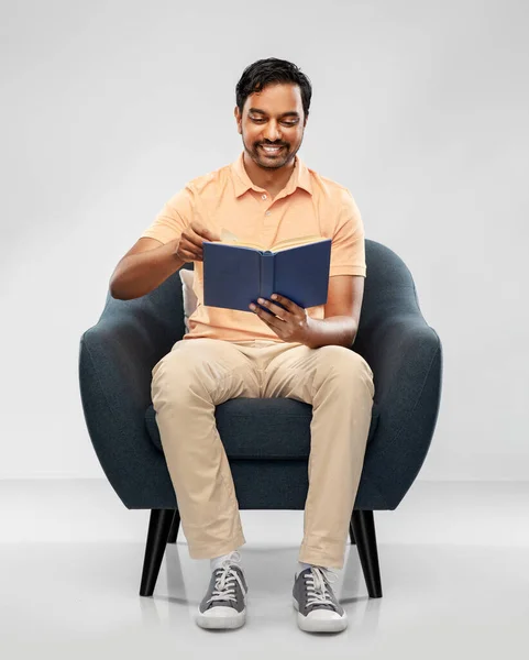 Heureux jeune homme indien lecture livre dans la chaise — Photo