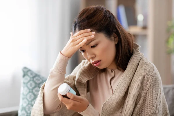 Zieke aziatische vrouw met pijnstiller geneeskunde thuis — Stockfoto