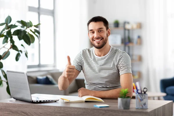 happy man with laptop working at home office