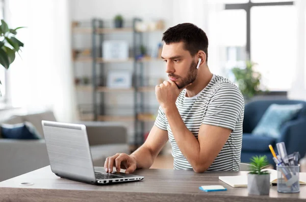 Uomo con laptop e auricolari a casa ufficio — Foto Stock