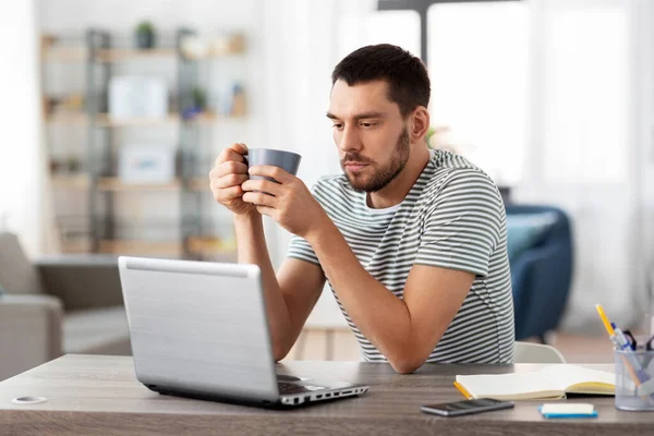 Hombre con portátil beber café en casa oficina — Foto de Stock