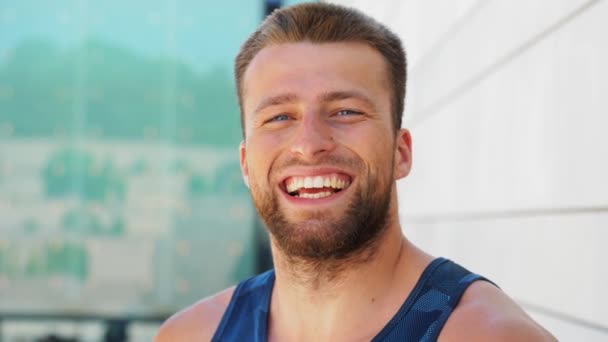 Портрет счастливого улыбающегося молодого человека на улице — стоковое видео