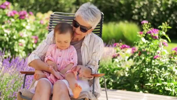 Gelukkig grootmoeder en baby kleindochter in tuin — Stockvideo