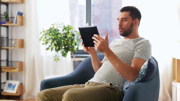 Homem feliz com tablet pc ter chamada de vídeo em casa — Vídeo de Stock