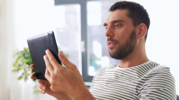 Glücklicher Mann mit Tablet-PC mit Videoanruf zu Hause — Stockvideo