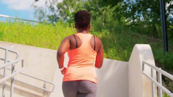 Junge afrikanisch-amerikanische Frau läuft die Treppe hinauf — Stockvideo