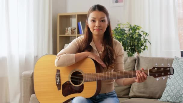 Ung kvinna med gitarr videobloging hemma — Stockvideo