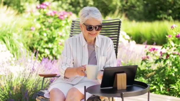 Mujer mayor feliz con la tableta PC en el jardín de verano — Vídeo de stock