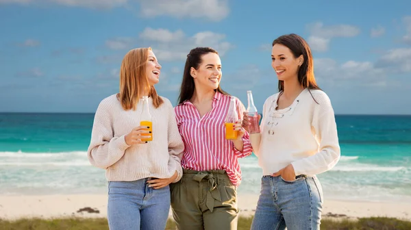 Mulheres jovens com bebidas não alcoólicas na praia — Fotografia de Stock