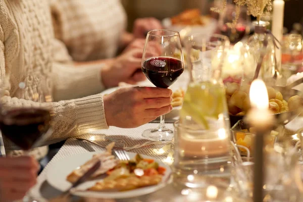 Przyjaciele pijący czerwone wino na przyjęciu świątecznym — Zdjęcie stockowe