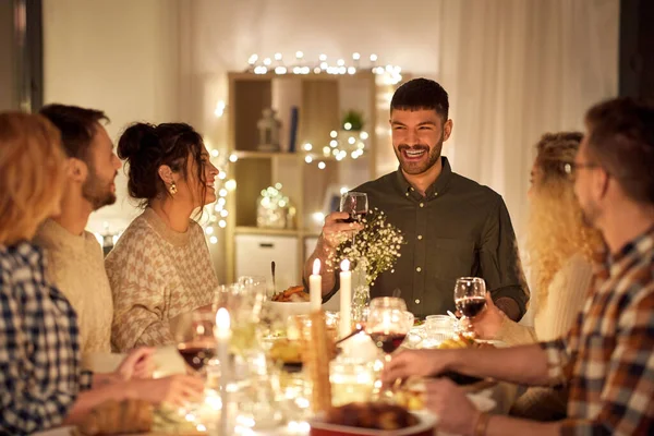 Amigos felizes bebendo vinho tinto na festa de Natal — Fotografia de Stock