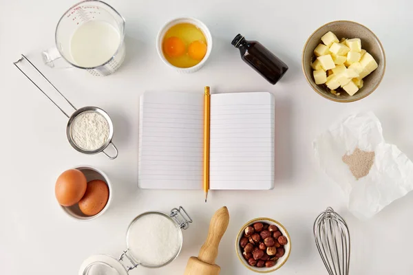Книга рецептов и ингредиенты для приготовления пищи на столе — стоковое фото