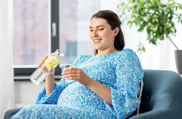 幸せな妊婦が家で果物の水を飲んで — ストック写真