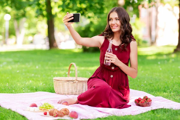 Femme heureuse avec smartphone prendre selfie au parc — Photo