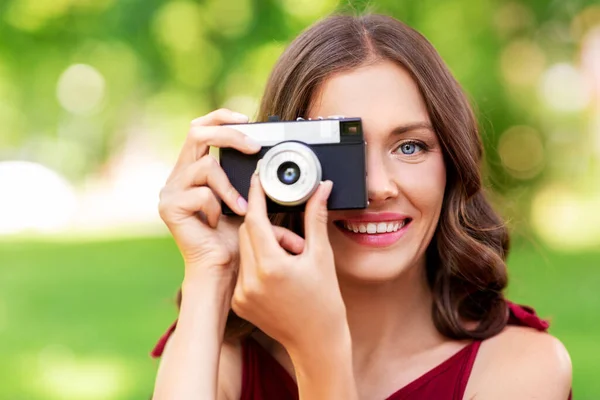 Lycklig kvinna med kamera fotografering i parken — Stockfoto