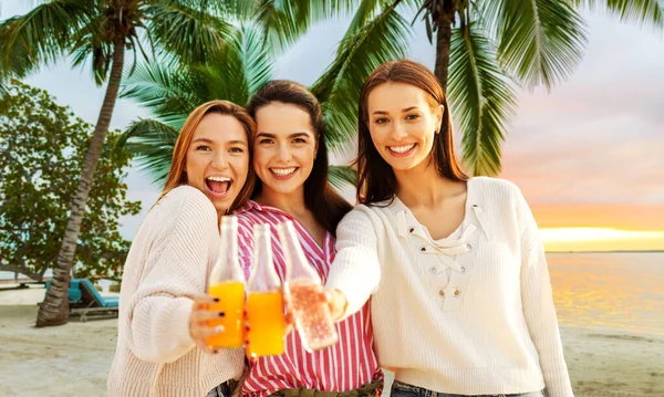 Mulheres jovens brindando bebidas não alcoólicas na praia — Fotografia de Stock