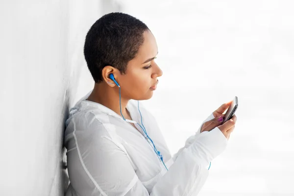 Donna afroamericana con auricolari e telefono — Foto Stock