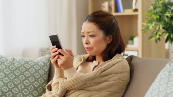Mujer enferma triste en manta usando teléfono inteligente en casa — Vídeo de stock